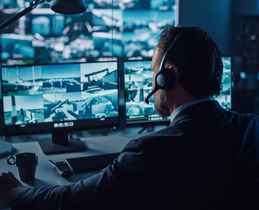 Back view of a man looking at security footage