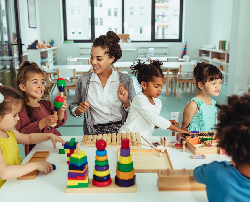 Front view of daycare instructor playing with children