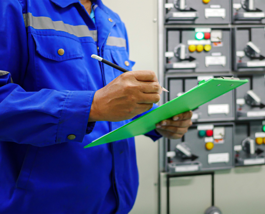 Side view of man writing something down on clipboard