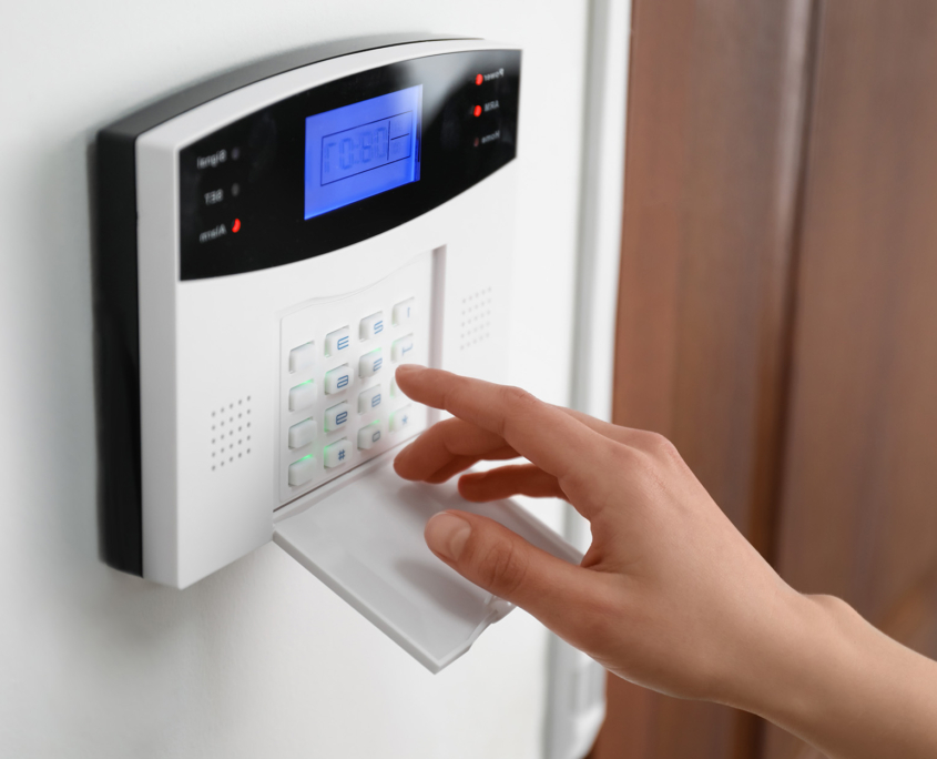 Side view of someone's finger pressing on a security surveillance system
