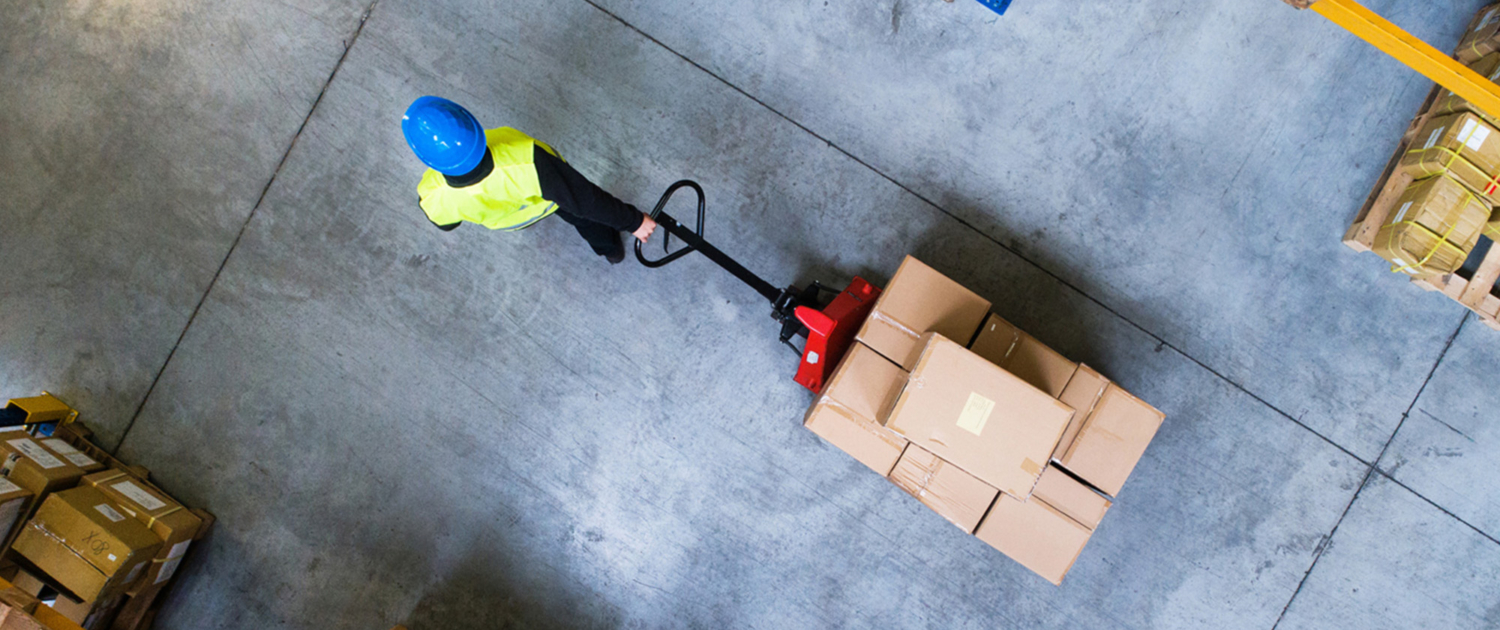 Top-down view of a warehouse worker hauling boxes with a jack
