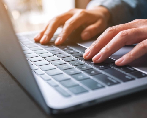 Side view of someone typing on a laptop