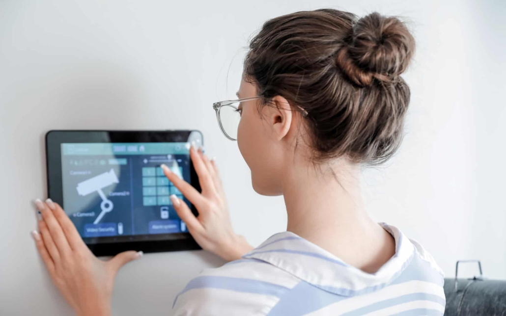 Woman using smart home security system control panel