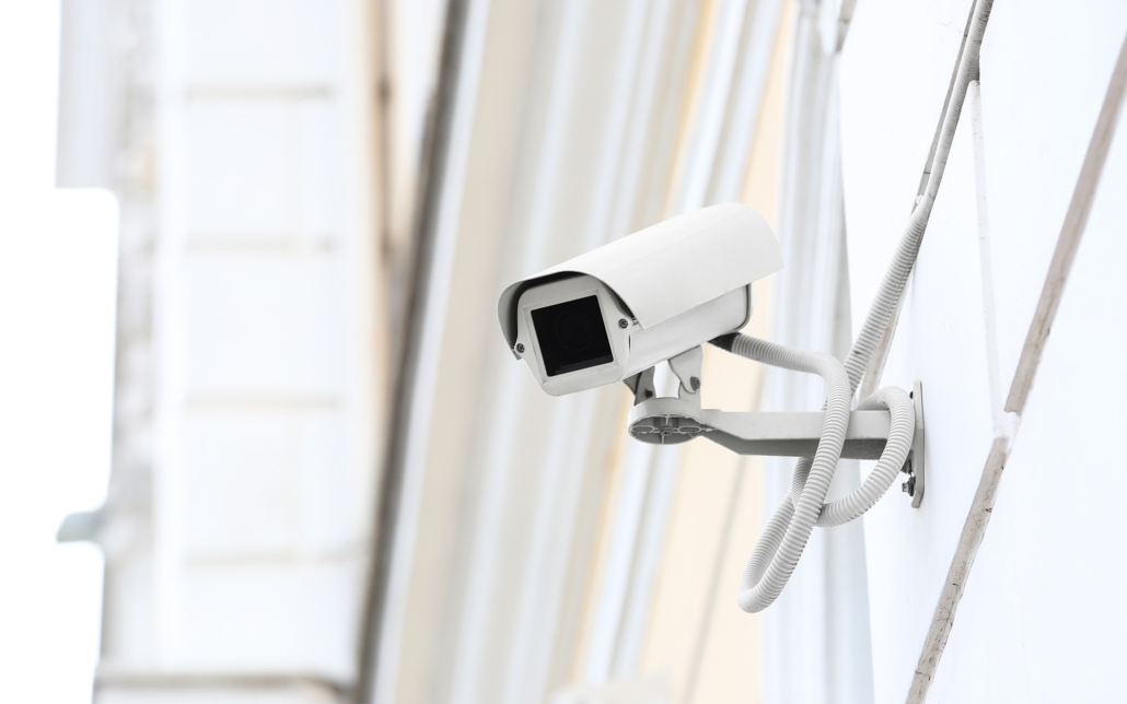Modern CCTV camera installed on wall of building outdoors