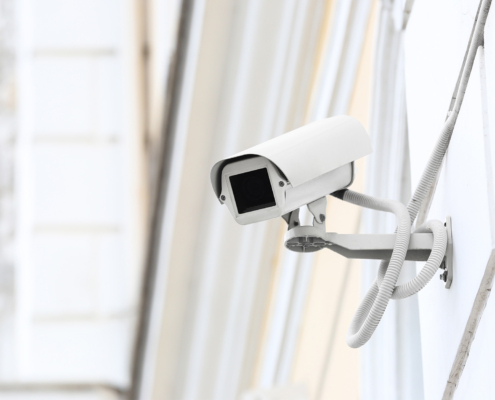 Modern CCTV camera installed on wall of building outdoors