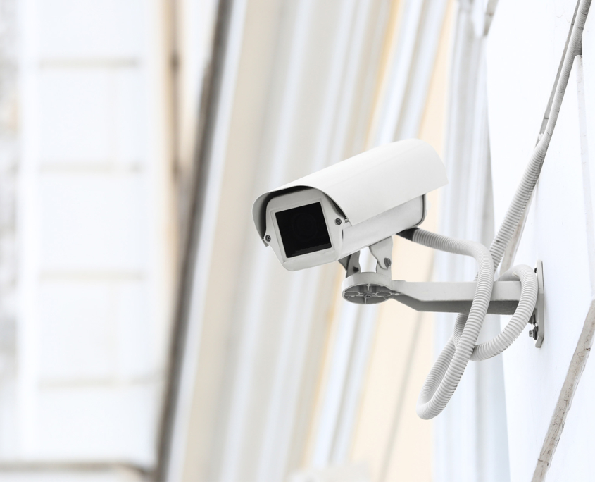 Modern CCTV camera installed on wall of building outdoors