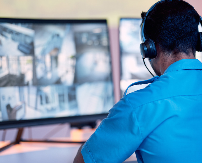 Security guard, headphones and cctv monitor